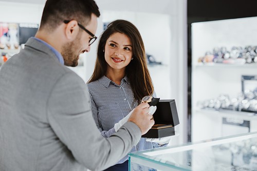 woman helping a man who is shopping for a watch image