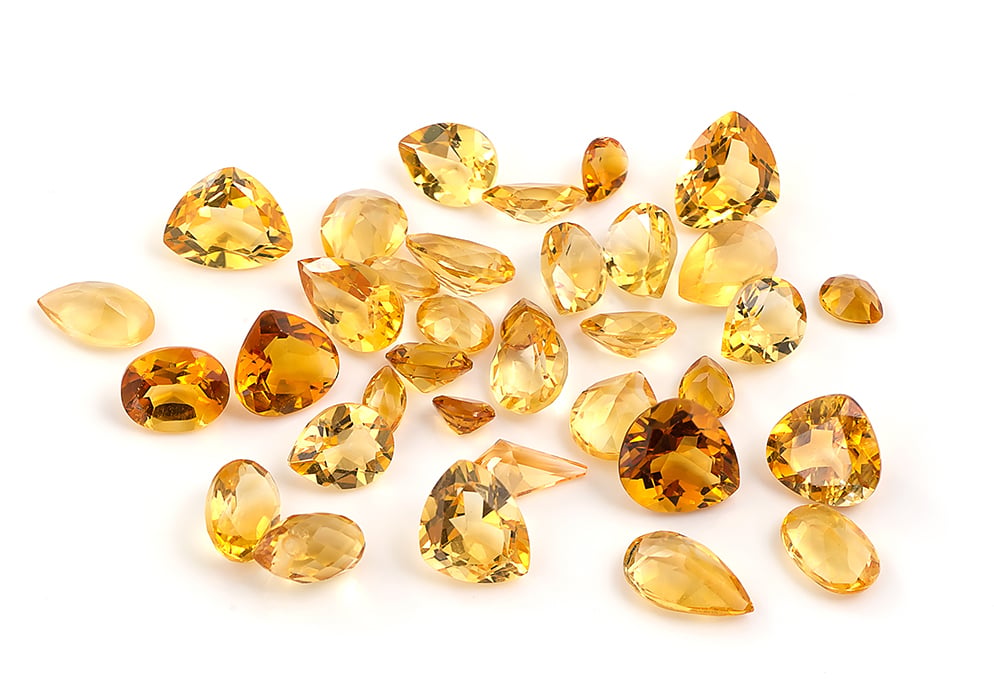 November Birthstone Guide for Retailers – Citrine & Topaz 1 Assortment of orange and yellow colored citrine gemstones image