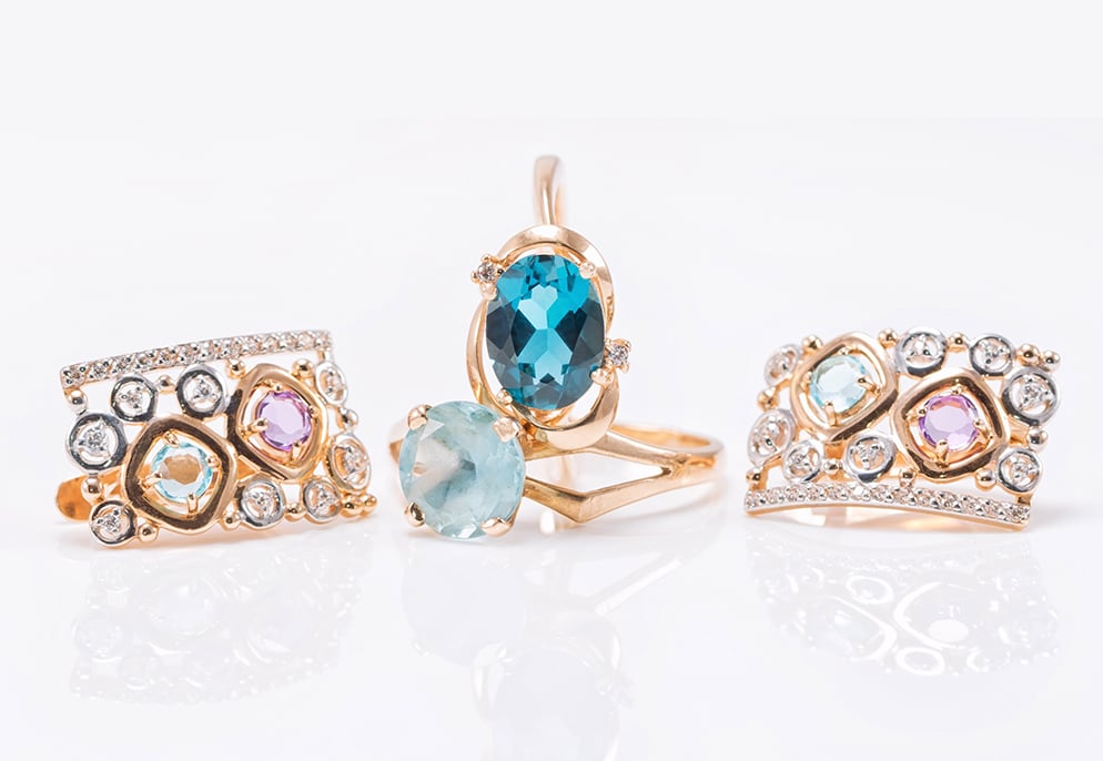 November Birthstone Guide for Retailers – Citrine & Topaz 4 Blue Topaz gemstones set in gold rings image