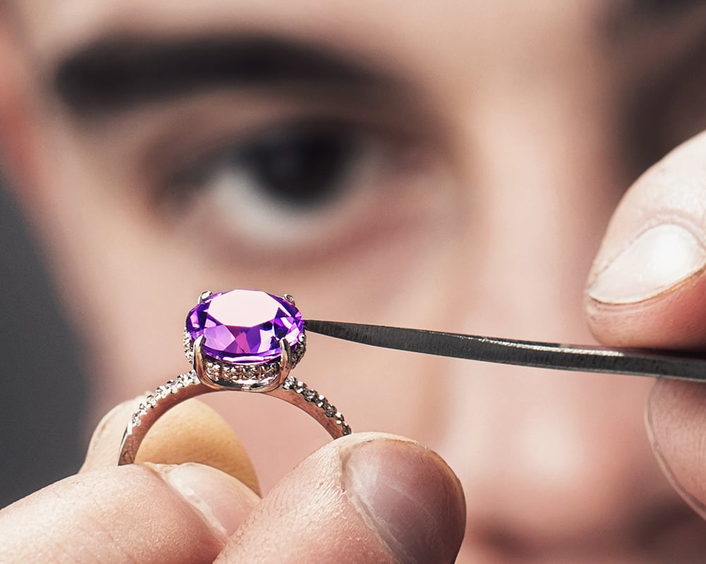 February Birthstone Guide for Retailers – Amethyst 5 Jeweler examining an amethyst gem set in an engagement ring image